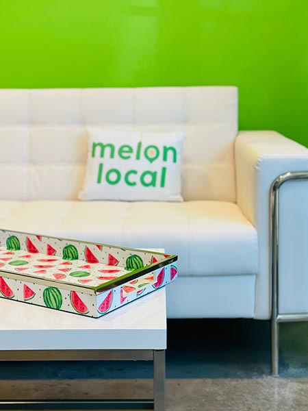 White couch with a Melon Local throw-pillow