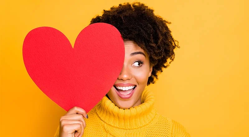 Woman smiling while holding a heart