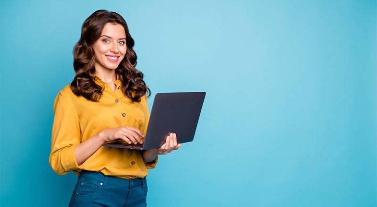 Woman smiling while holding a laptop