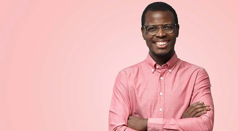 A man smiling with his arms folded