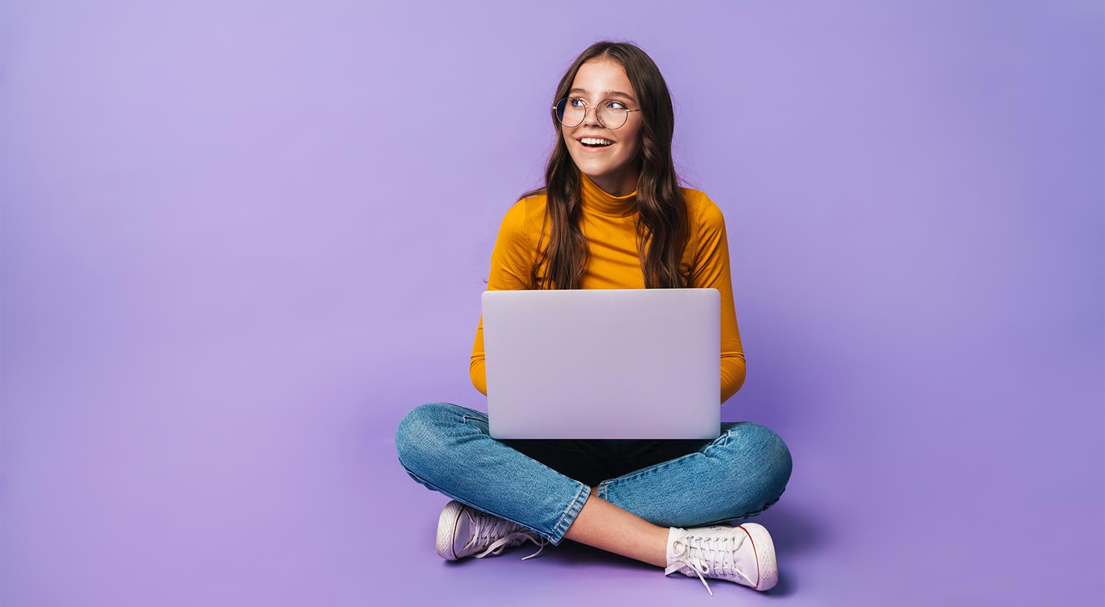 A woman sitting on the floor with a laptop