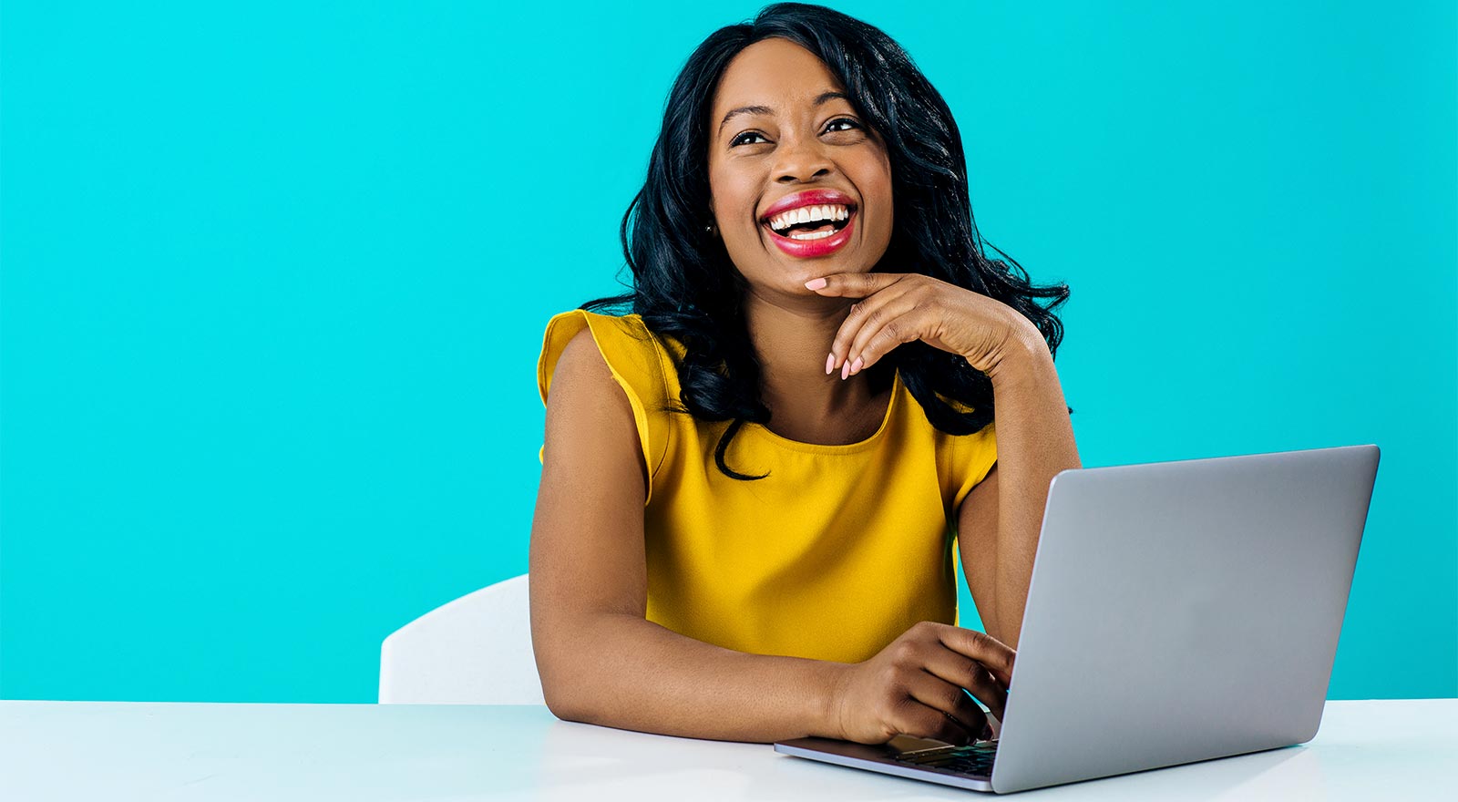 A woman smiling while on her laptop
